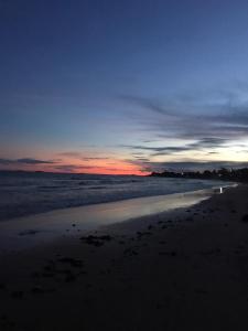 um pôr-do-sol numa praia com o oceano em Pousada Sombra das Ondas em Guarapari
