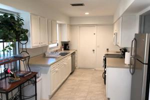 een keuken met witte kasten en een koelkast bij San Carlos Paradise! in Fort Myers