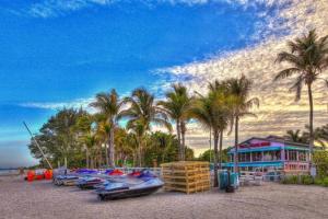 a row of boats parked on a beach with palm trees at San Carlos Paradise! in Fort Myers