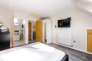 - une chambre avec un lit et une télévision murale dans l'établissement Bright&Modern Contractor House by Niji Short Stays, à Manchester