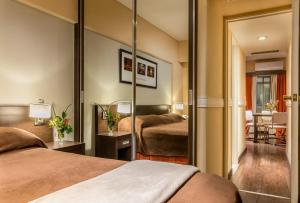a hotel room with two beds and a mirror at Up Viamonte Hotel in Buenos Aires