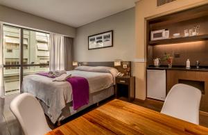 una camera con un letto e due sedie bianche di Up Viamonte Hotel a Buenos Aires