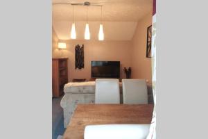 a dining room with a table and chairs and a television at Otters' Raft in Weston-super-Mare