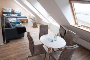 a room with a table and chairs and a bed at Witte Kliff Helgoland in Helgoland