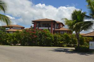 a house with palm trees in front of a driveway at Praia do Forte, Piscinas Naturais in Praia do Forte