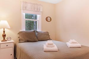 1 dormitorio con 1 cama con toallas en Whale Rock Lodge, en Madison