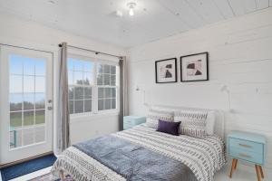 ein weißes Schlafzimmer mit einem Bett und einem Fenster in der Unterkunft Sunset Beach Getaway in Moclips