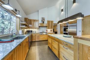Black Butte Ranch的住宿－Rockrose - East Meadow 65，一个带木制橱柜和花岗岩台面的大厨房