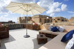patio z kanapą i parasolem na dachu w obiekcie GetawayNpetto Private Duplex Maisonette with Jacuzzi Hot Tub w mieście Mġarr