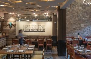 a dining room with tables and chairs and a person in the background at Hotel Jackson in Jackson