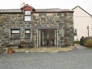 an old stone house with a red door at Hafod in Llanddeiniolen