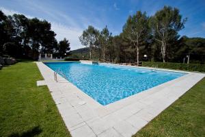 een zwembad met blauw water in een tuin bij Sol Pins II - Salvador in Tamariu