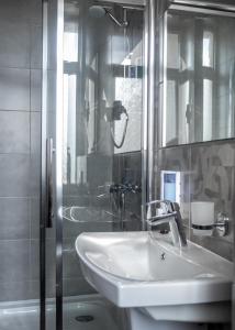 y baño blanco con lavabo y ducha. en Hotel DoZari en Korostyshiv