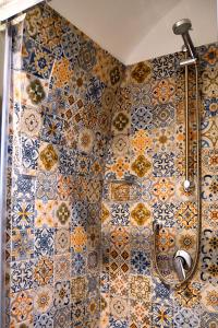 a bathroom with a shower with tiles on the wall at Il mito in Castellaneta