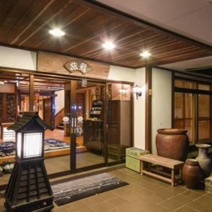 una habitación con una lámpara y un jarrón. en ELE Hotel Onsen Ryokufutei en Kusatsu