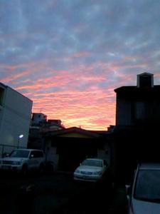 a sunset with cars parked in front of a building at Takigawa Ryokan in Kyoto