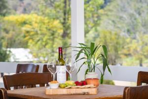 a wooden table with wine glasses and fruit on it at The Cottage on Lamington in Canungra
