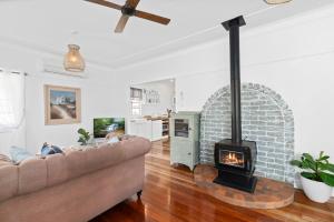 a living room with a brick fireplace and a couch at The Cottage on Lamington in Canungra