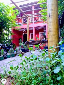czerwony dom z roślinami przed nim w obiekcie Suites Casa De Ban w mieście Lençóis