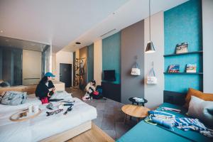 two people sitting on a bed in a room at Hoshino Resort BEB5 Tsuchiura in Tsuchiura