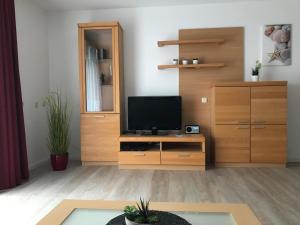 a living room with a television on a wooden cabinet at Steiner Strandappartements Appartement 208 Süd- Landseite in Stein