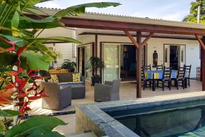 une terrasse avec une table, des chaises et une piscine dans l'établissement Villa Oasis, à Fa'a'ā