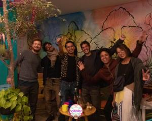 un groupe de personnes posant une photo devant un mur dans l'établissement Hostal Casa Colores Adults Only, à Guadalajara