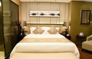 a bedroom with a large bed with pillows at Shenzhen LANGYUE International Hotel in Longgang