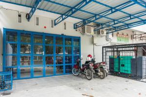 a motorcycle parked in a garage with blue doors at RedDoorz near Manhattan Square Medan in Pulauberayan