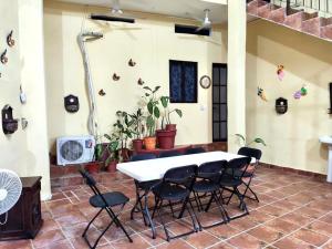 a white table and chairs in a room with plants at POSAD FAMILIAR EL PARAiSO in Xilitla