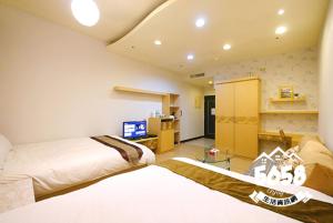 a bedroom with two beds and a tv in it at 85 Vacation ApartHotel in Kaohsiung