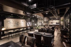 a restaurant with tables and chairs and a bar at Westory Design Poshtel in Kanchanaburi City