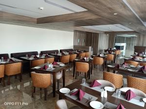 BalāngīrThe Hotel Celebration的餐厅里有桌椅的餐厅