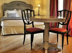 Siri Hotel في فانو: طاولة وكرسيين في غرفة بها سرير