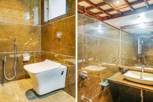 a bathroom with a toilet and a shower and a sink at FabHotel Gravity Inn Baner in Pune