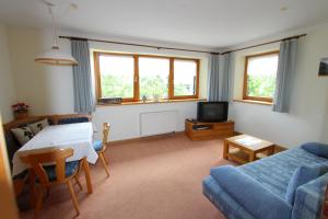 a living room with a couch and a table at Ferienwohnung Maag in Lechbruck