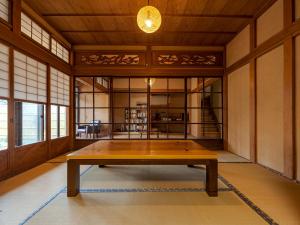 una grande stanza con un tavolo al centro di ゲストハウス メグルヤ 中山道柏原宿 a Maibara