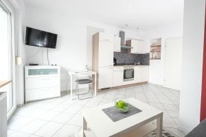 a kitchen with white cabinets and a table in a room at Apartment mit Wohnflair in Essen