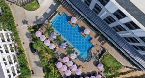 una vista aérea de una piscina con sillas y sombrillas en Sawaddi Patong Resort & Spa by Tolani - SHA Extra Plus, en Patong Beach