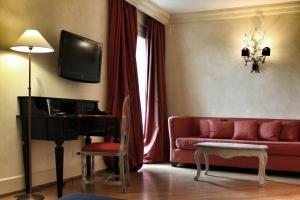 a living room with a red couch and a television at Siri Hotel in Fano