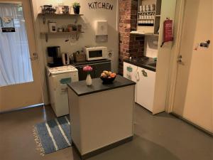 a kitchen with a counter with a bowl of fruit on it at Hostel Suomenlinna in Helsinki