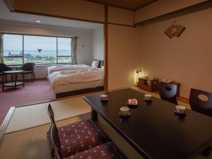 a hotel room with a bed and a table and chairs at Aso Hotel in Aso