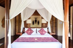 1 dormitorio con 1 cama grande y cortinas blancas en WakaGangga en Tabanan