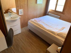 a small bedroom with a bed and a sink at AmdenLodge - Berg Chalet in Amden am Walenssee - Event, Seminar, Ferienlager in Amden