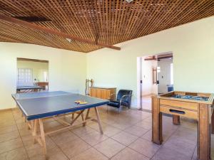 a ping pong table in a living room with a table at Hotel Fazenda Morada Do Imperador in Barbacena