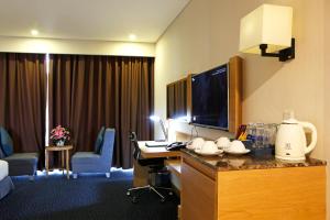 Ciao SaiGon Hotel & Spa في مدينة هوشي منه: غرفة في الفندق بها مكتب وبه جهاز كمبيوتر وتلفزيون