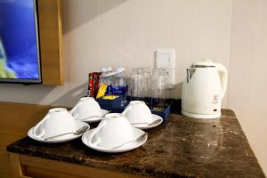 a counter with white dishes and a blender on it at Ciao SaiGon Hotel & Spa in Ho Chi Minh City