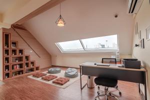an attic office with a desk and a window at The Victory View in Bangkok