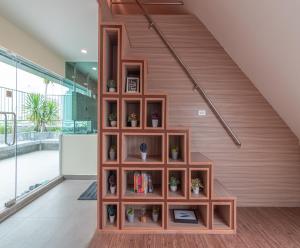 a wooden book shelf under a stair case at The Victory View in Bangkok