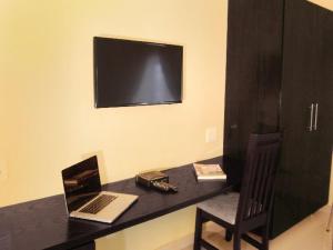 escritorio con ordenador portátil y silla en la habitación en Booth Suite Hotel Mafikeng en Mafikeng
